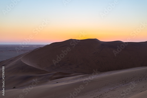 Colorful sunset over the Namib desert, Namibia, Africa. Scenic sand dunes in backlight in the Namib Naukluft National Park, Swakopmund.