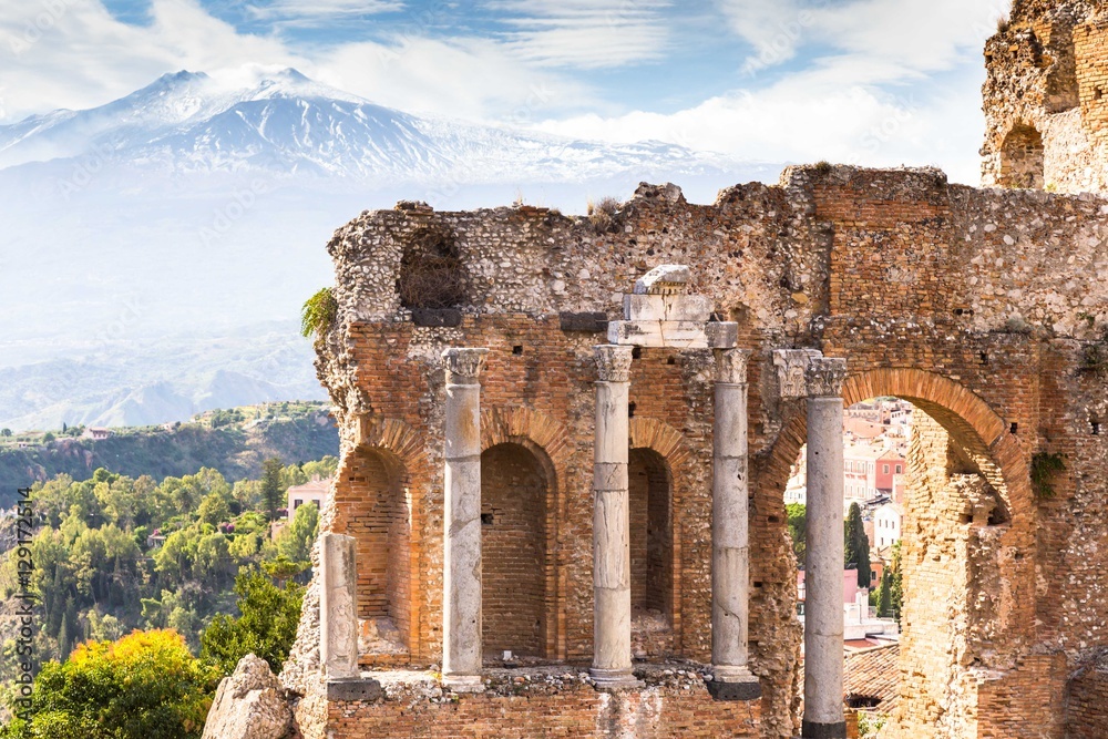 Ruins and columns of antique greek theater in Taormina and Etna Mount in the background. Sicily, Italy, Europe.