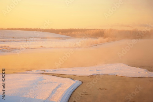 ice and snow in the river at the sunset in winter background