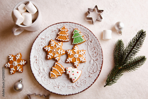 Fotografie Beautiful Christmas background with gingerbread cookies on a white plate with a