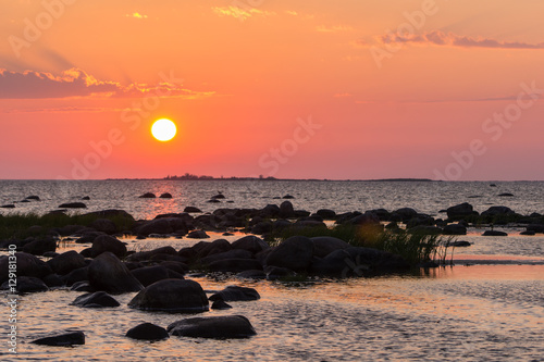 Sunset rocky beach  peaceful sea  orange sky. Kihnu  small island in Estonia. Baltic sea  Europe. Natural environment background.