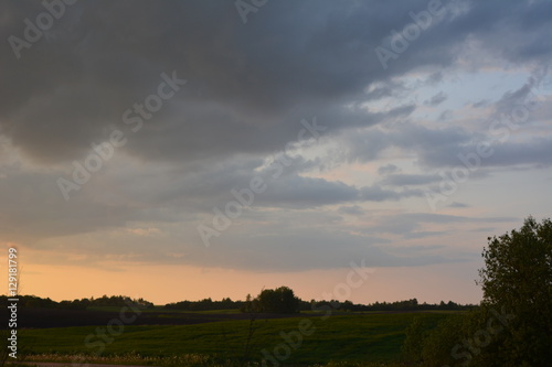 beautiful spring sunset over the field, nature, landscape, bright sky and dark clouds 