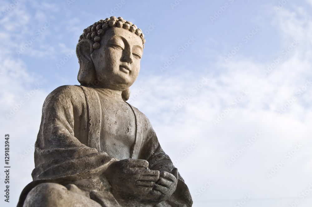 Sitting Buddha image in lotus position on sky background. Sitting Buddha image in lotus position on sky background.