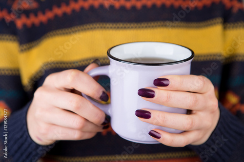 Woman in cozy sweater holding a cup