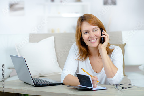 smiling woman on a phone call using laptop