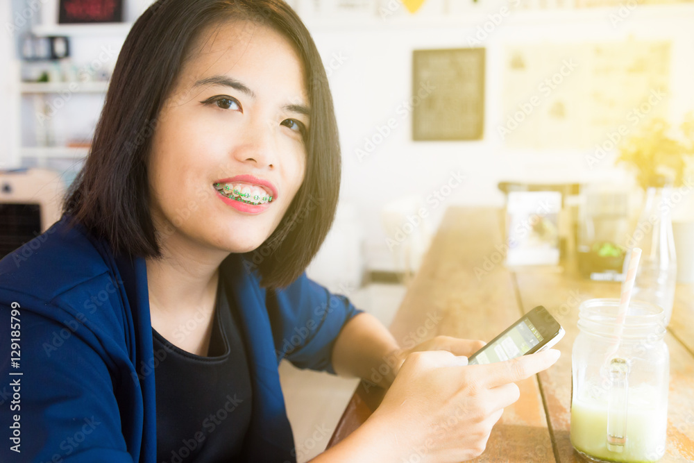 Smiling businesswoman with phone and laptop in cafe working for start up business, Technology and communication concept