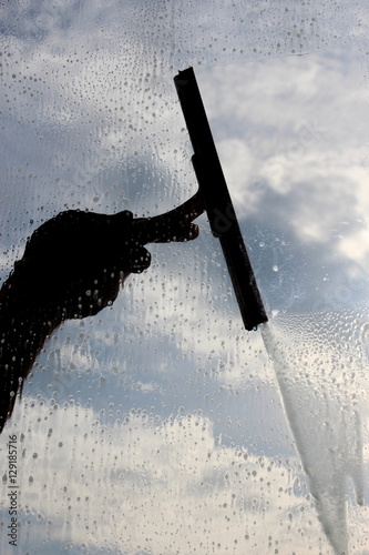 man cleaning the window with cloudy background  photo