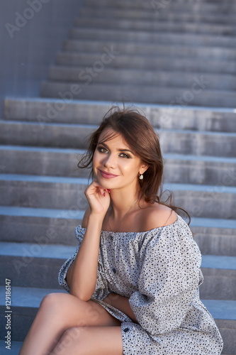 Beautiful girl in elegant dress and charming smile posing for the photographer in the city of Yekaterinburg. Business girl walks after work