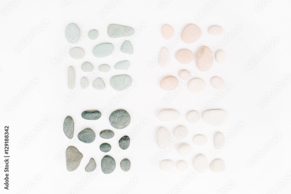 Creative arrangement of colored stones. Mint, pink, beige and grey stones on white. Flat lay, top view Creative arrangement of colored stones. Mint, pink, beige and grey stones on white. Flat lay, top view