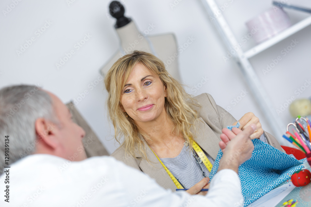 Obraz premium happy fashion designer talking to male client