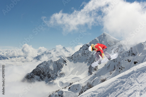 Snowboard rider jumping on mountains. Extreme snowboard sport.