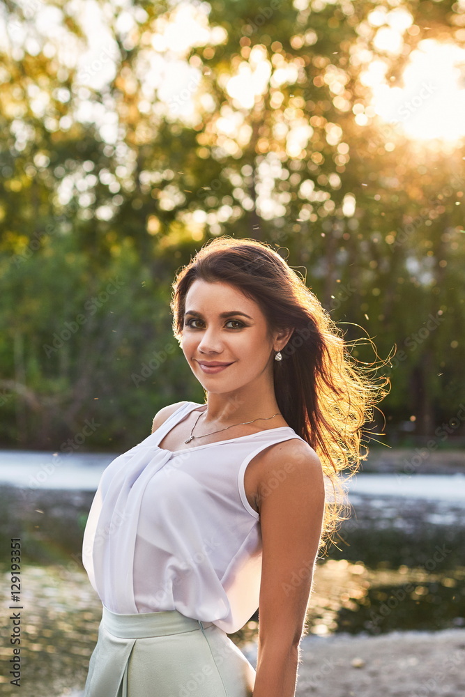 Beautiful girl in elegant dress and charming smile posing for the photographer in the park of Yekaterinburg. Business girl walks after work Beautiful girl in elegant dress and charming smile posing for the photographer in the park of Yekaterinburg. Business girl walks after work