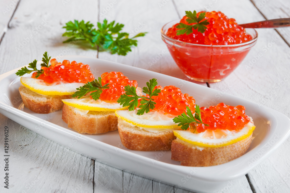 Red caviar on bread with lemon and parsley Red caviar on bread with lemon and parsley