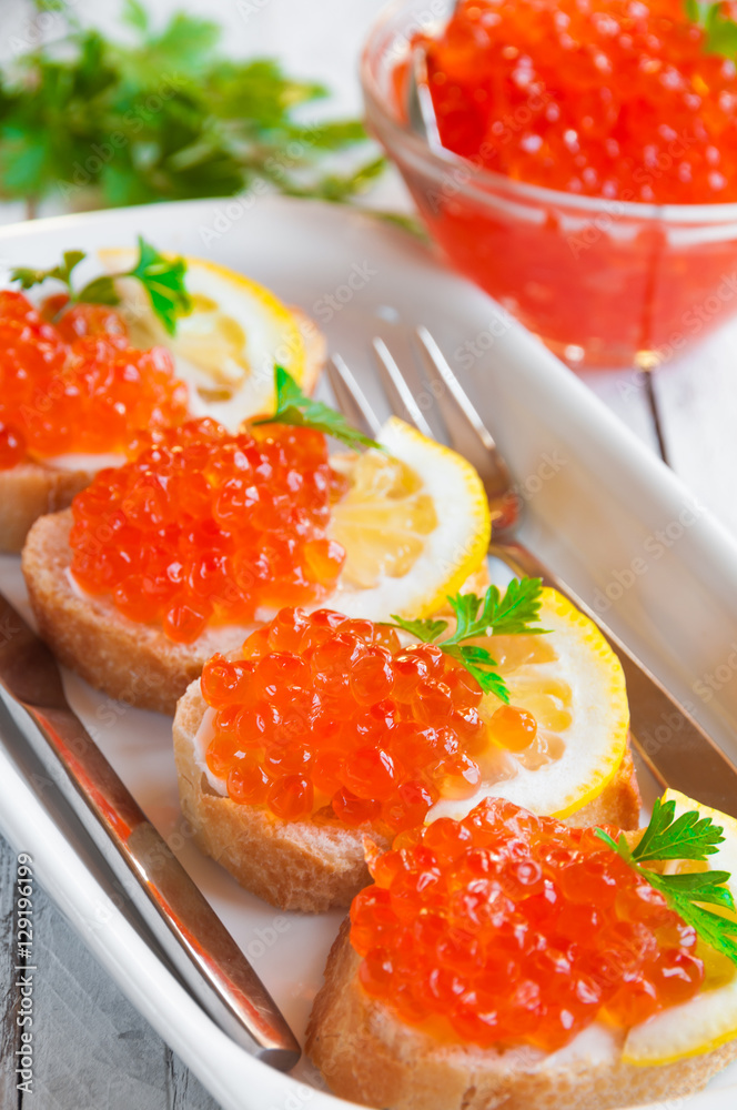 Red caviar on bread with lemon and parsley Red caviar on bread with lemon and parsley
