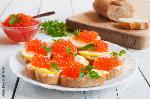 Red caviar on bread with lemon and parsley