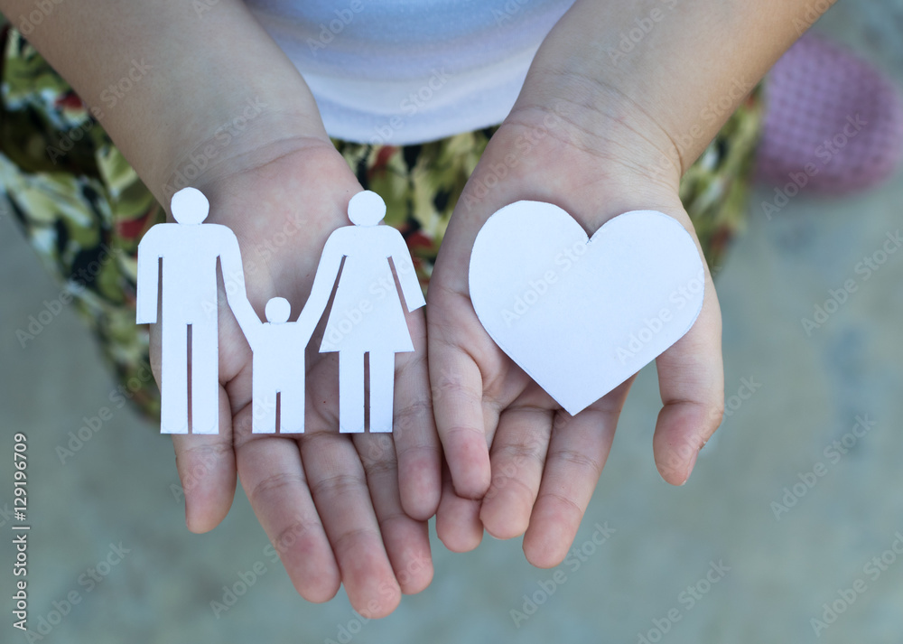 Children hands holding small model of heart and family , concept Children hands holding small model of heart and family , concept