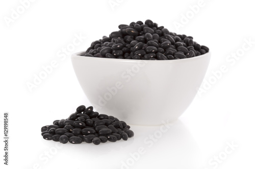Black turtle beans in a bowl isolated on white background