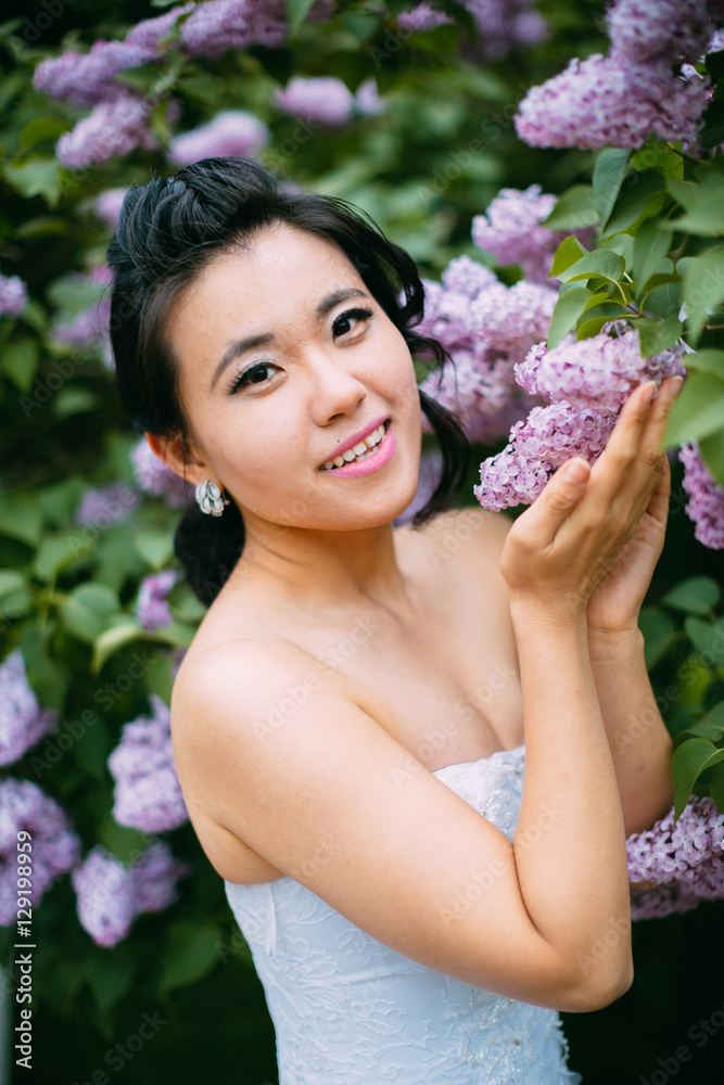Portrait of young pretty bride surrounded by lilac Portrait of young pretty bride surrounded by lilac