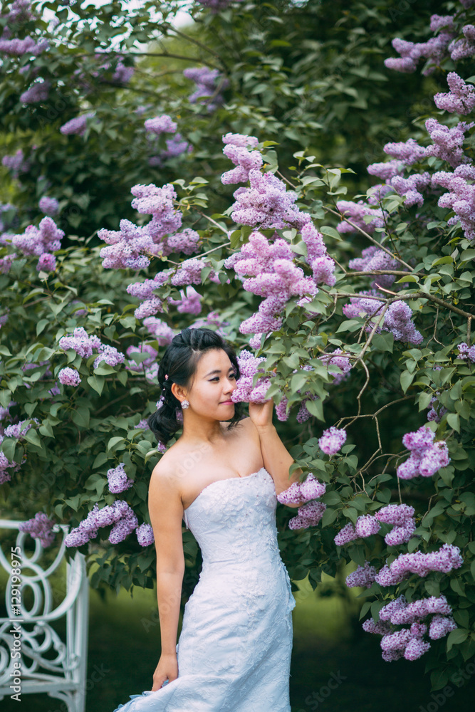 Portrait of young pretty bride surrounded by lilac Portrait of young pretty bride surrounded by lilac