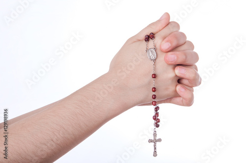 Female hands closed in prayer holding a rosary isolated on white background