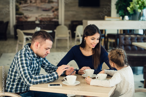 Family Enjoying tea In Cafe Together