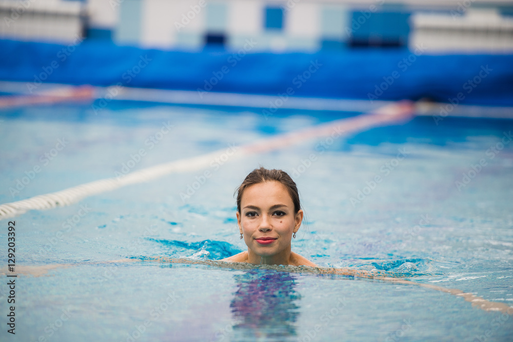 Smiling portrait of beautiful woman in swimming pool