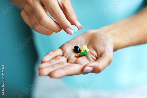 Vitamins And Supplements. Female Hand Holding Colorful Pills photo