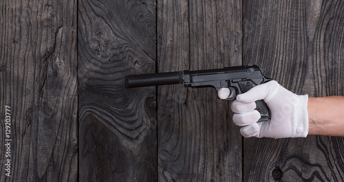 Foto with a pistol with a silencer hand