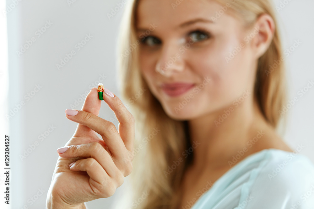 Vitamins And Food Supplements. Beautiful Woman With Pill In Hand Vitamins And Food Supplements. Beautiful Woman With Pill In Hand