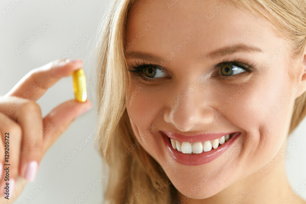 Vitamin And Supplement. Beautiful Woman Holding Fish Oil Capsule Vitamin And Supplement. Beautiful Woman Holding Fish Oil Capsule