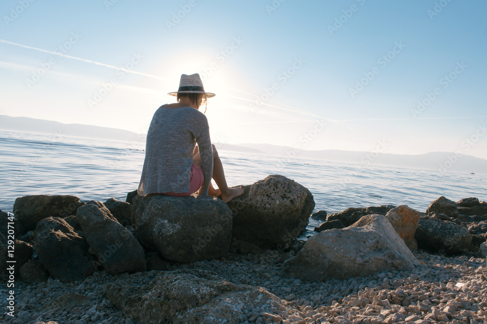 Young woman wearing hat, looking at beautiful view of sea Young woman wearing hat, looking at beautiful view of sea