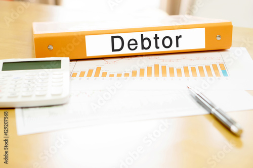 Fotografie, Tablou Orange  binder debtor on desk in the office with calculator and