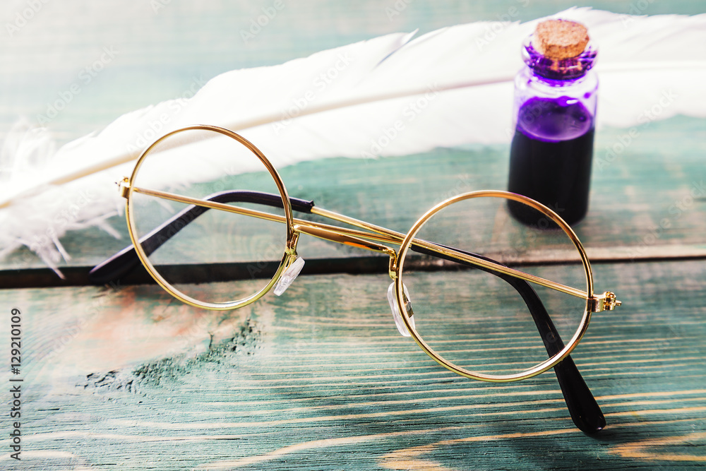 Φωτογραφία Closeup of old glasses near quill and inkstand on green wooden table