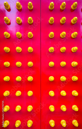 Red gate of a Chinese Temple with yellow door-nails on it. Shot in vertical angle. photo