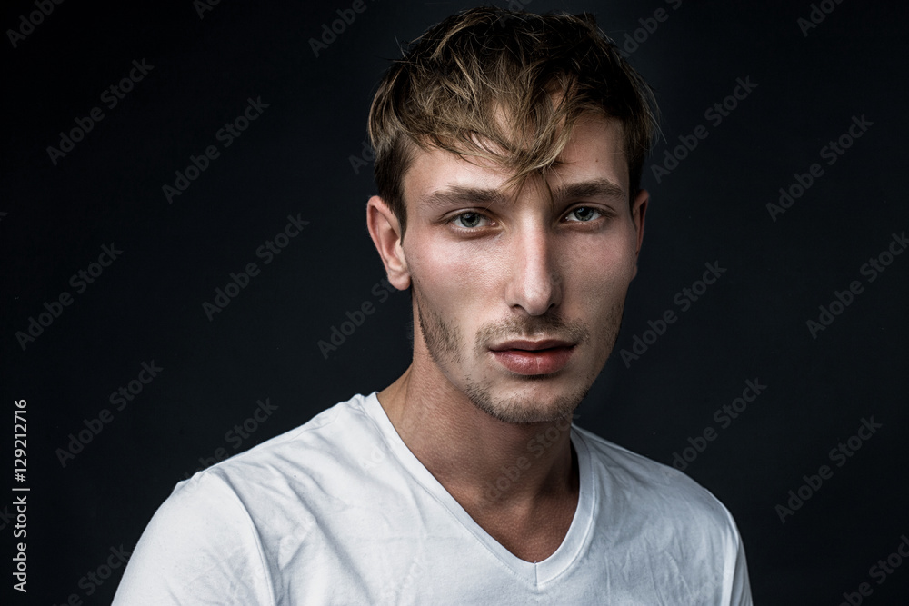 handsome young man in white t shirt posing in studio