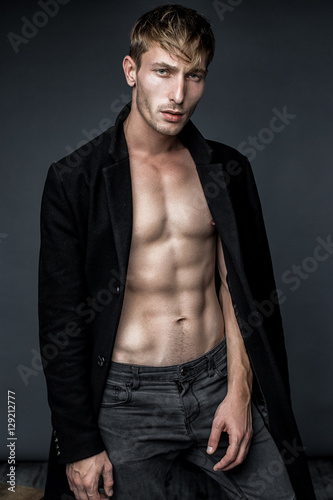 handsome young man in black jacket posing in studio