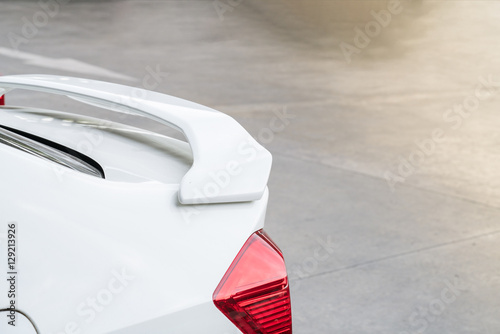 car part ; Close up detail of a custom racing carbon fiber spoiler on the rear of a modern car with copy space 