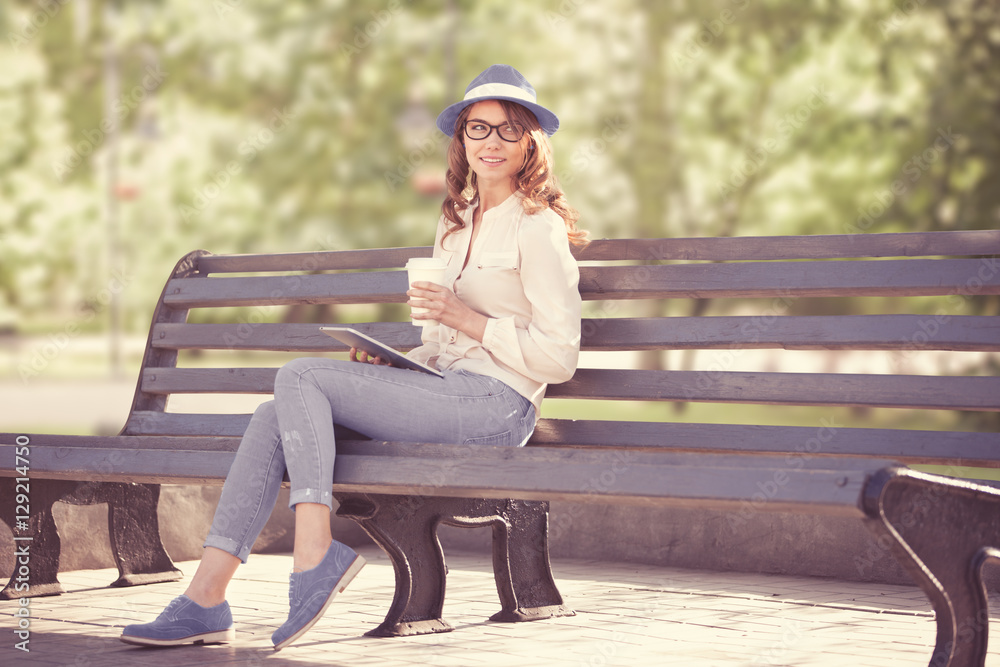 Sitting on the bench /A happy young student with a tablet pc and a disposable coffee cup sitting on the bench in a summer park.
Sitting on the bench /A happy young student with a tablet pc and a disposable coffee cup sitting on the bench in a summer park.