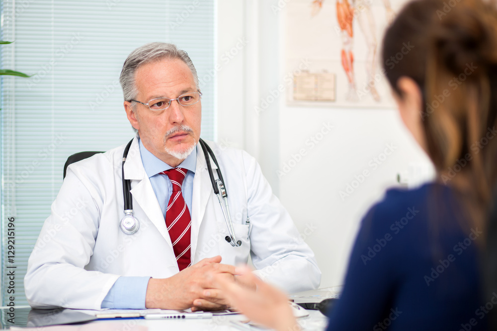 Doctor talking to a patient in his studio Doctor talking to a patient in his studio