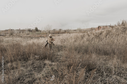 boy carries a wooden box. The boy found the artifact. wanderer in the world of the apocalypse. boy in a protective cloak and hood. a child soldier. young boy soldier. abandoned military base
