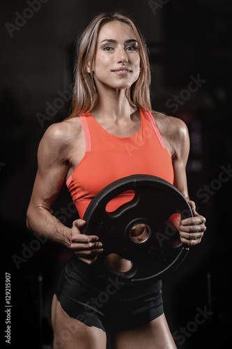 Athletic young woman posing and exercising fitness workout with