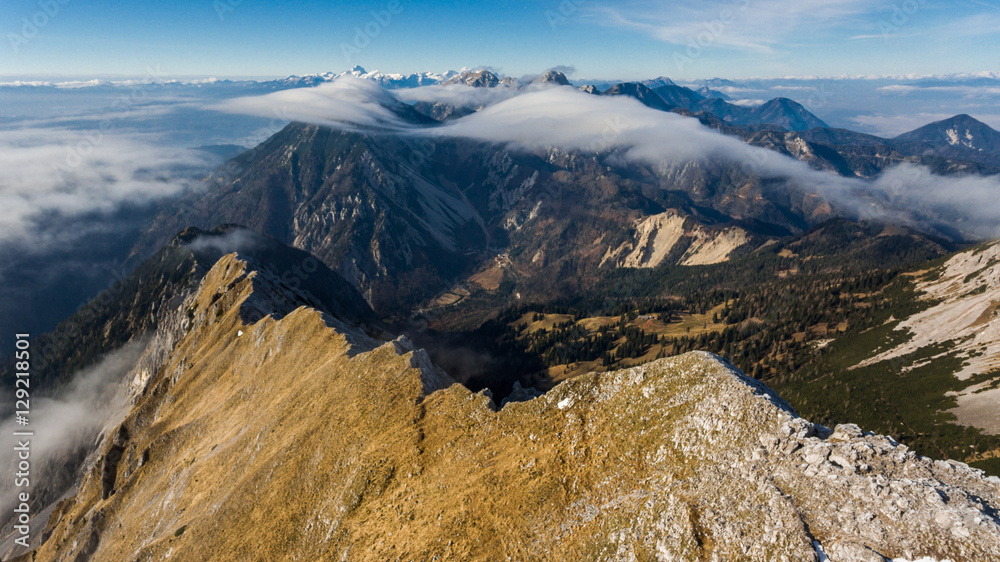 Aerial view above mountain ridge with river of clouds.