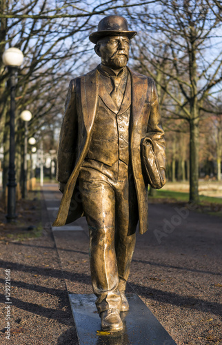 Golden man statue Walking Man in Tallinn, Kadriorg Park in Estonia photo