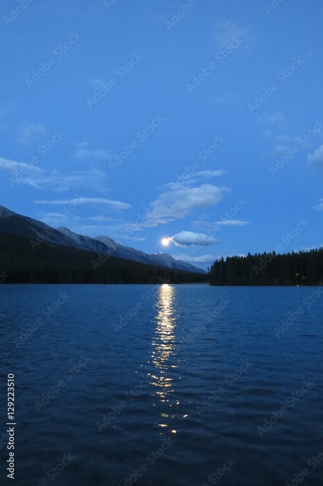 Moonrise with clouds over a lake. Banff, Canada.