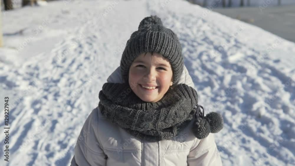 Sunny day portrait of young smiling girl on snow background Sunny day portrait of young smiling girl on snow background