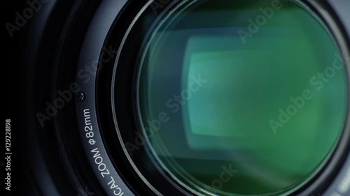 Static closeup shot of a professional video camera while it's lens is zooming.