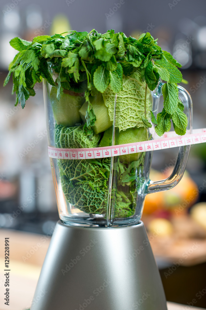 Close up view on the blender full of green fruits and vegetables ready to mix meter in kitchen. Healthy vegetarian diet for weight loss and detox Stock Photo | Adobe