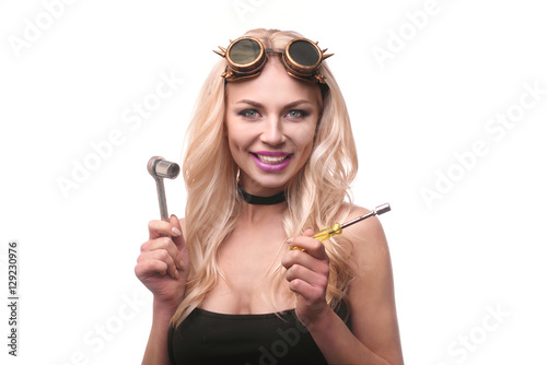 blond girl auto mechanic holding spanner over shoulder, isolated over white photo