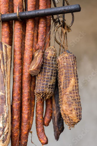 Hanging smoked homemade pork meat and sausages