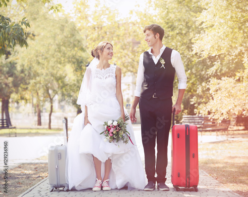 Groom and bride with suitca...
